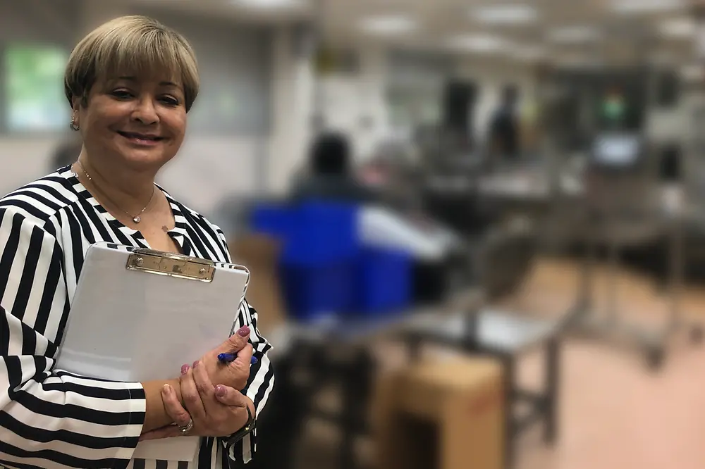 Woman holding clipboard smiling at camera