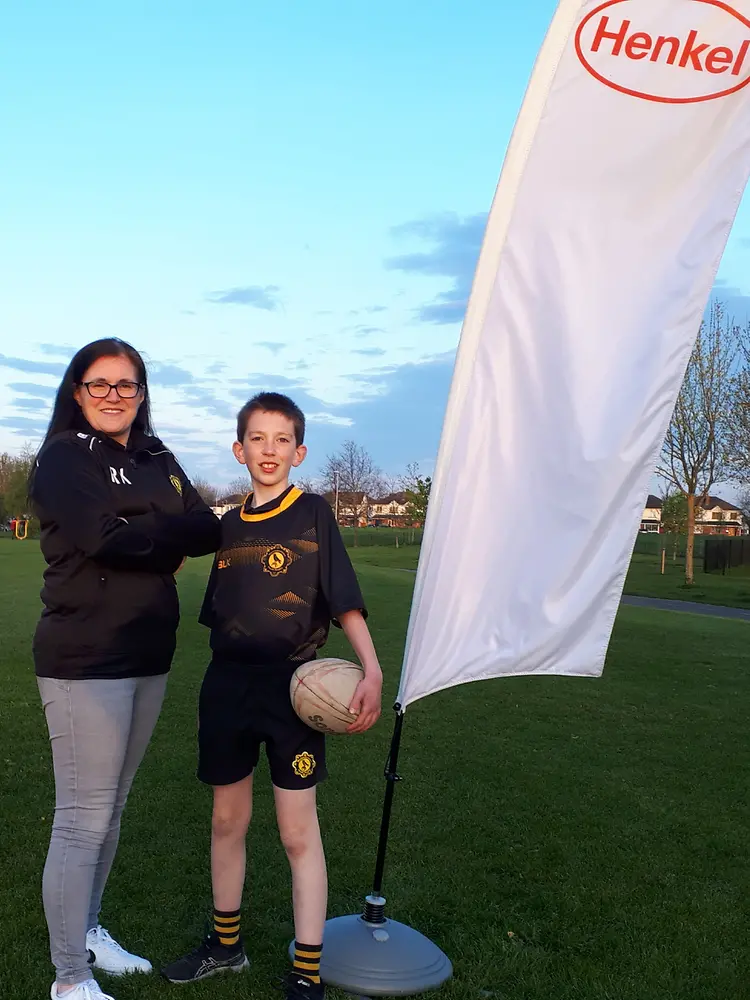 a woman and her son next to a Henkel banner
