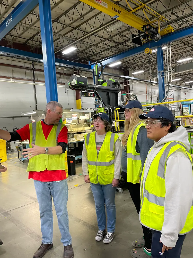 4 people in visibility vests in a logistics hall