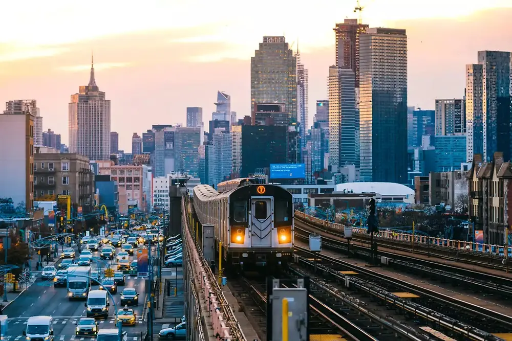 Urban train traveling through a modern city skyline during daytime.