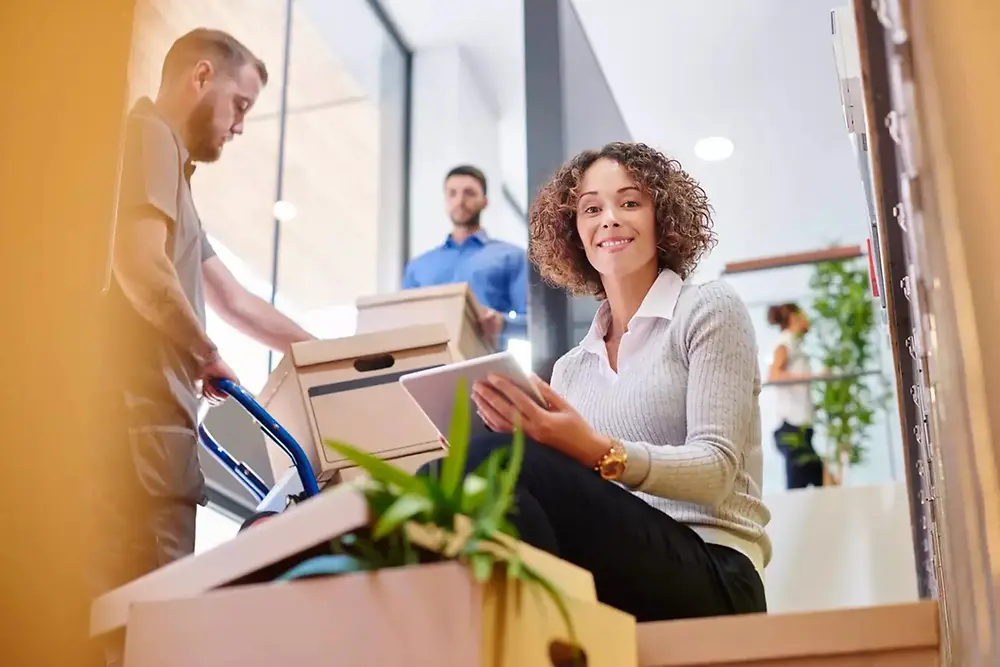Delivery worker handing a package to a smiling woman at home.