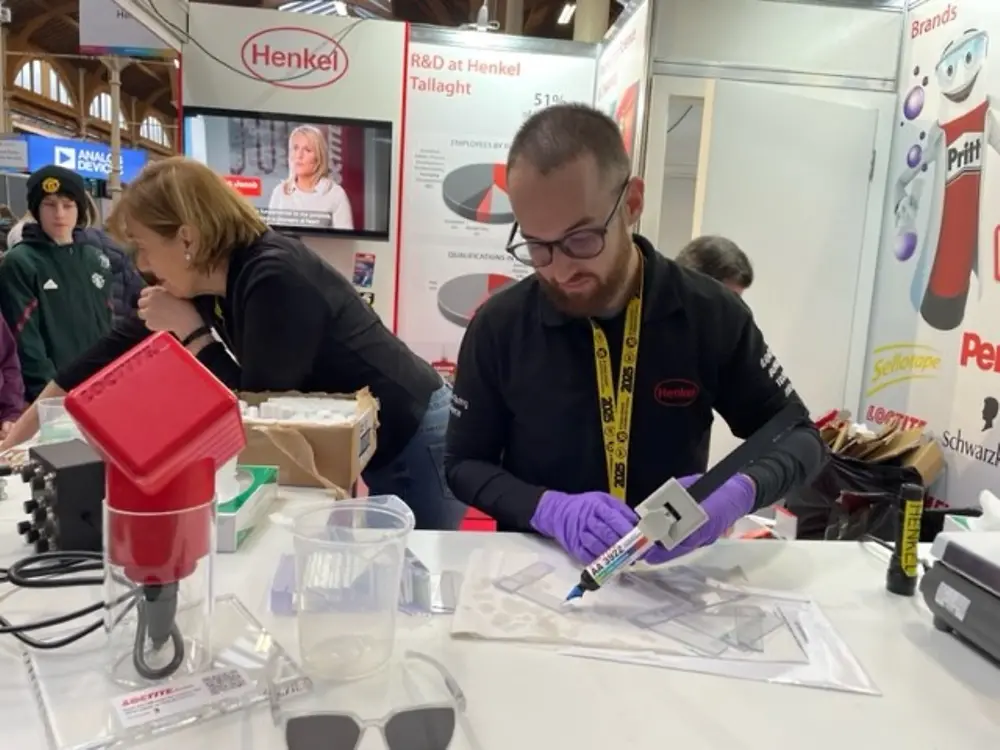 Man holding glue gun glues pieces together