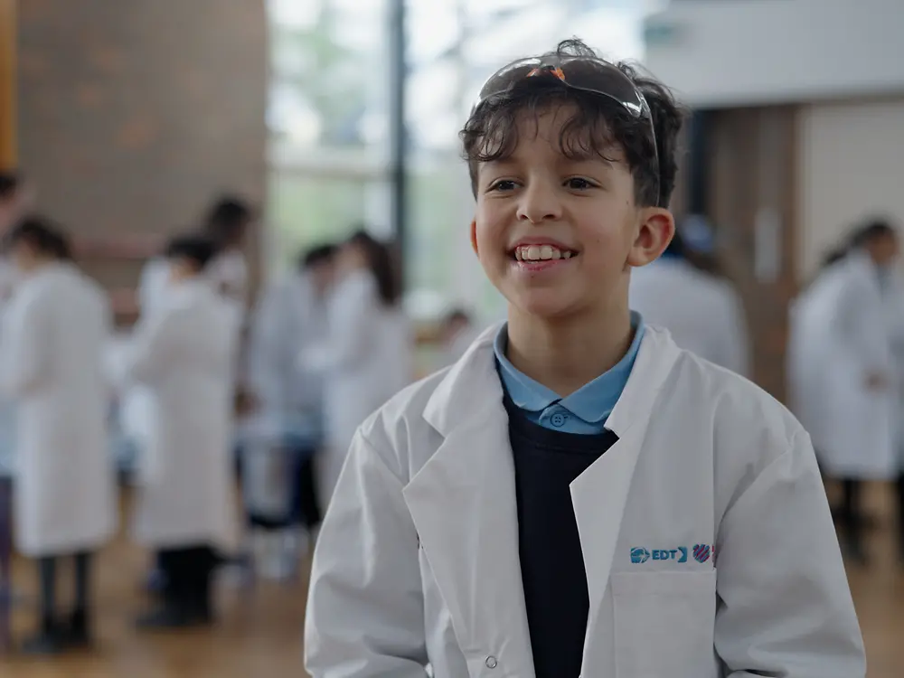 a child in a lab coat smiling