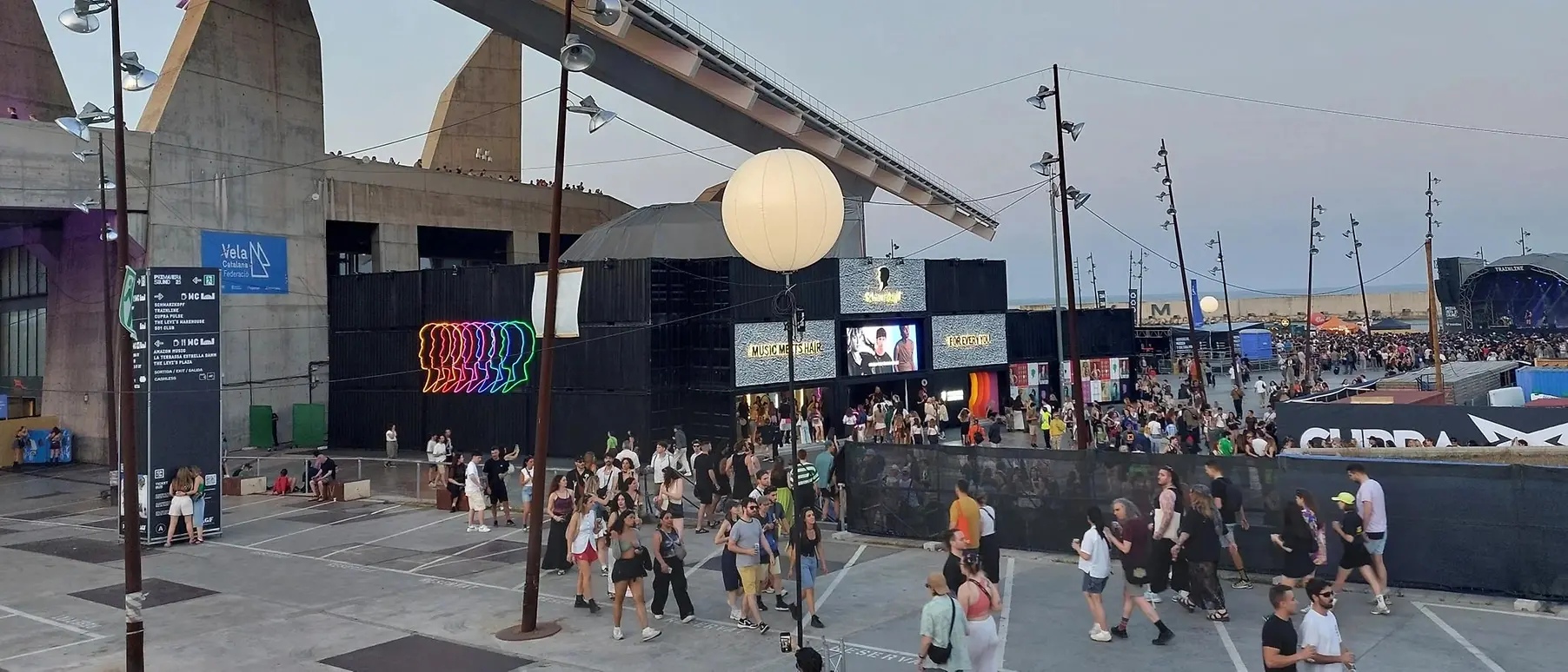 Stage with Schwarzkopf logo at a music festival, with crowds of people.