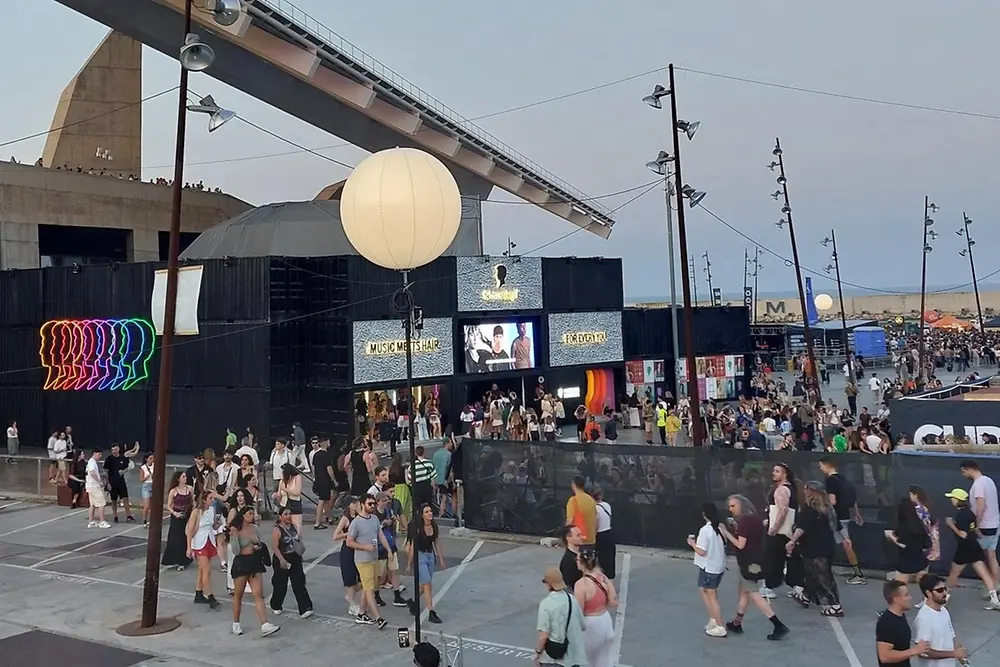 Stage with Schwarzkopf logo at a music festival, with crowds of people.