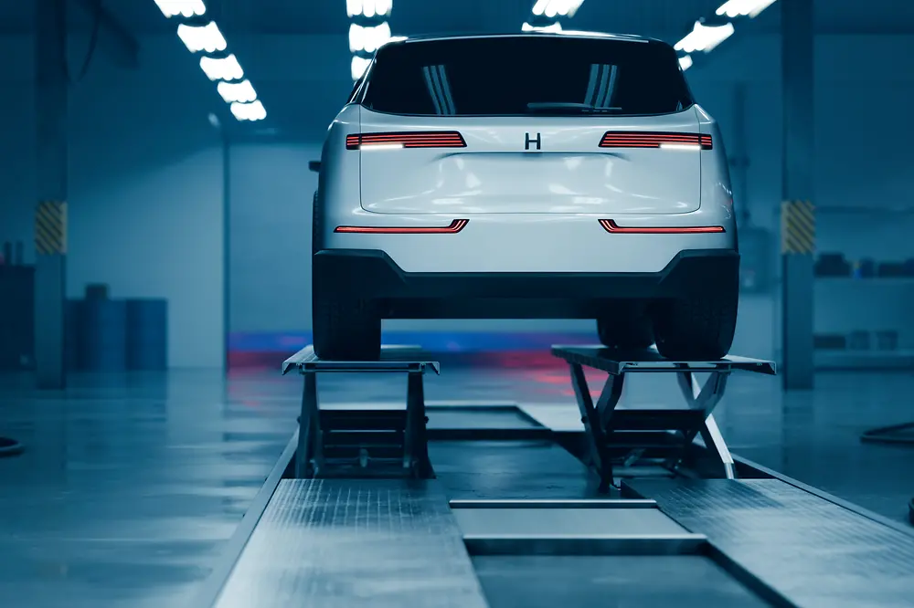 An image of an electric vehicle raised on a platform indoors