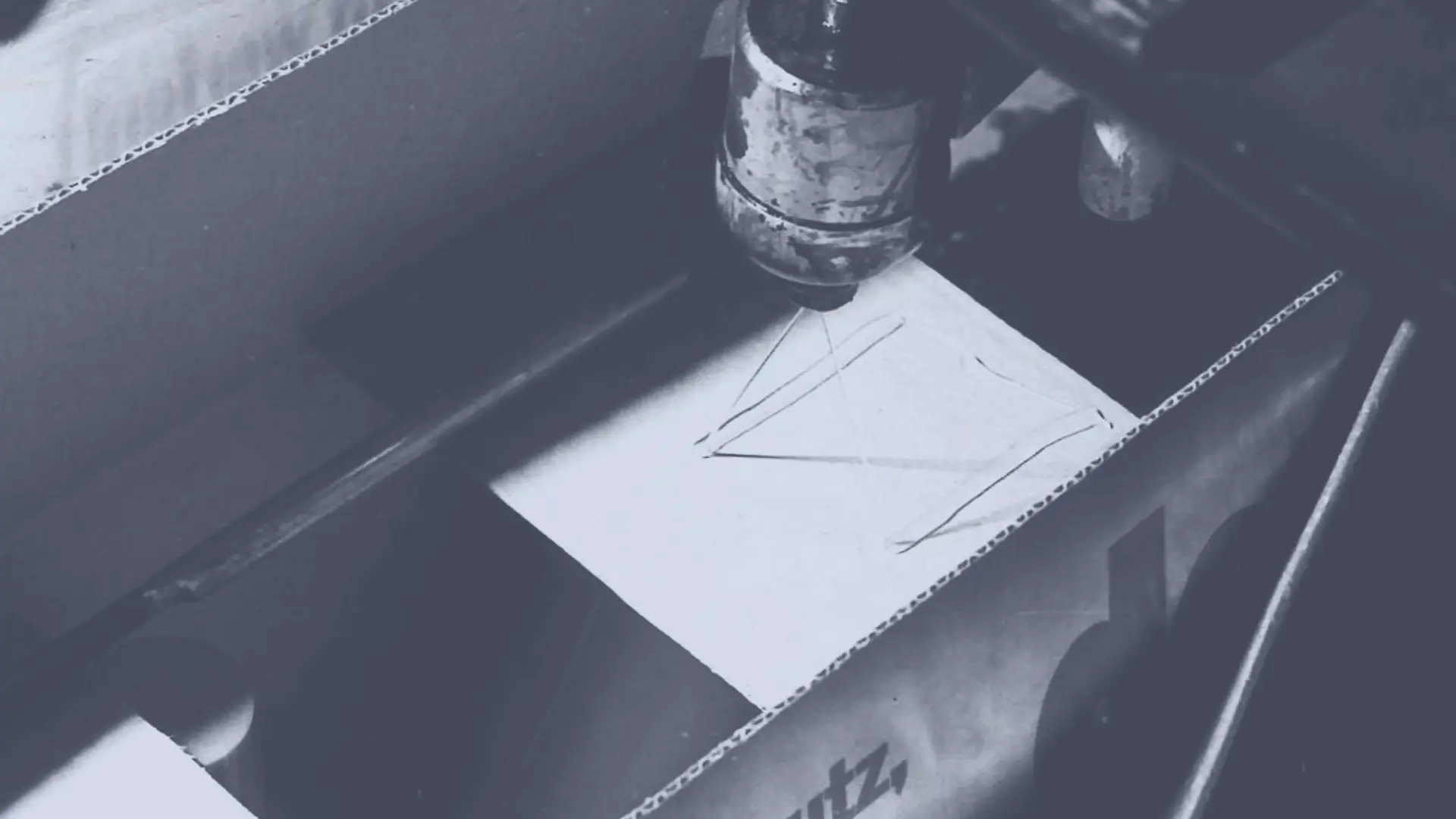 L’adhésif thermofusible Technomelt est appliqué sur une boîte en carton par une tête de pulvérisation pour la sceller.
